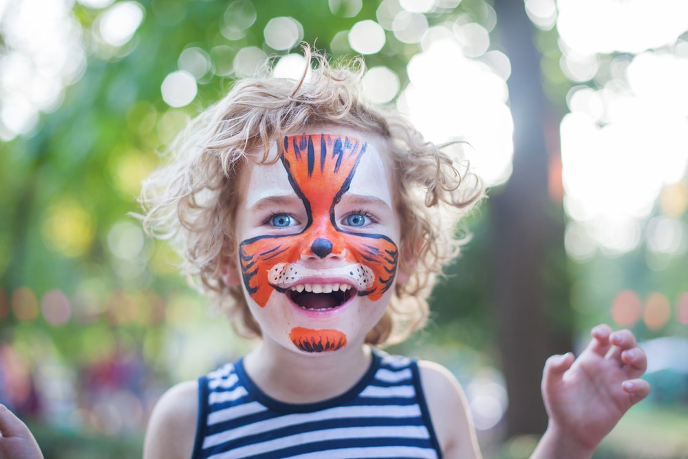 A view of a boy wearing tiger face paint