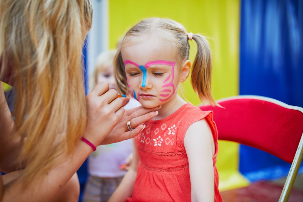 A view of a girl wearing butterfly face paint