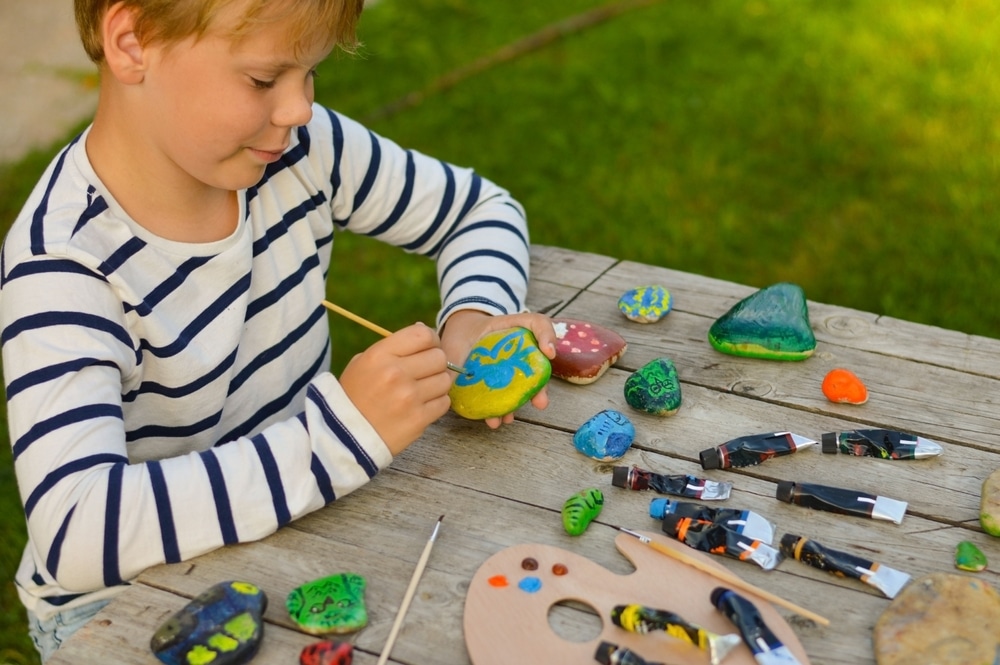 A view of a kid painting rocks