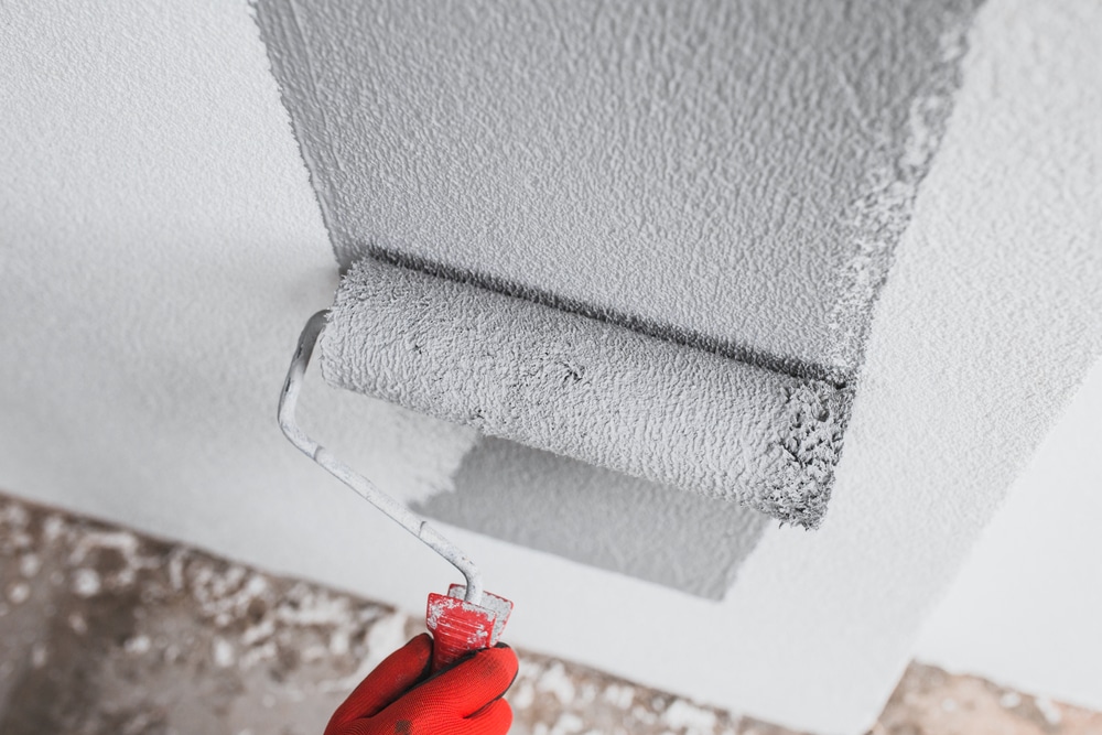 A view of a person finishing a wall with a roll on paint