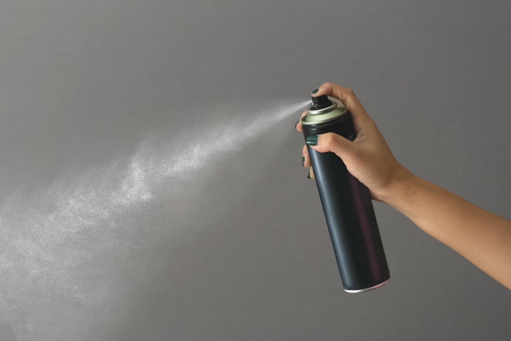 A view of a person holding a spray