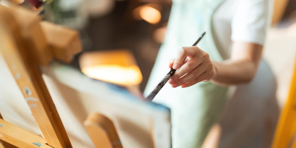 A view of a person painting on a canvas