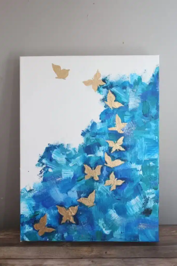 A abstract art painting with golden butterflies on a white canvas