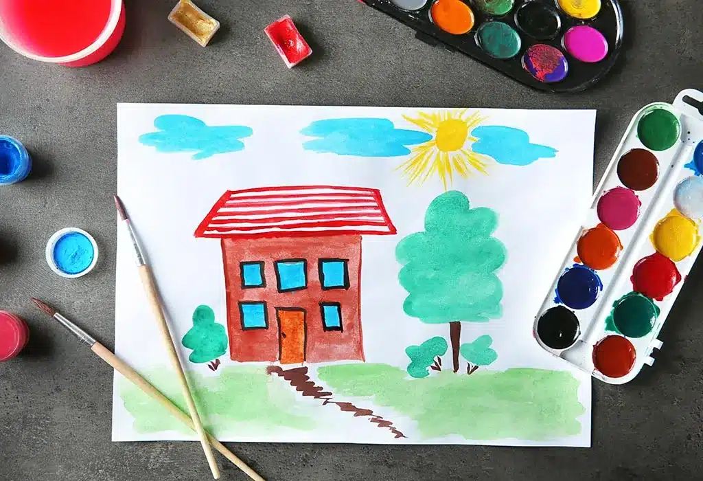 A top view of a painting of a house and trees for beginners with a water paint box