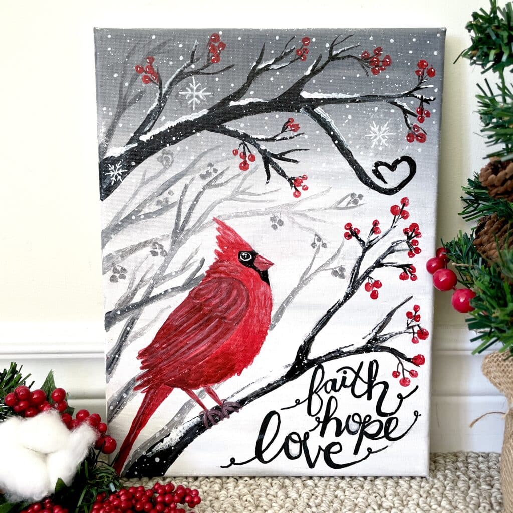 Christmas cardinal painted on a snowy branch on a canvas