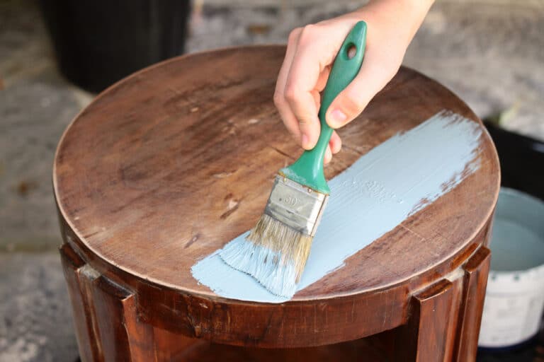 Close up view of human hand painting furniture