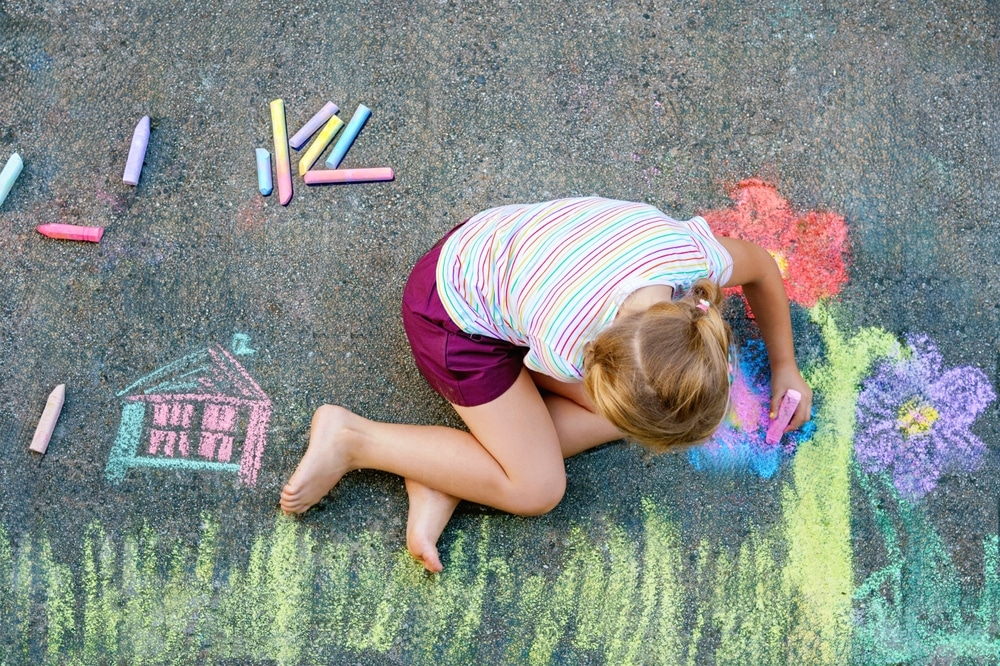 Cute Little Girl And Flowers Painted With Colorful Chalks On