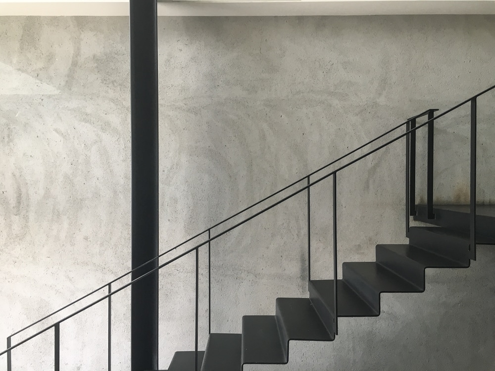 Industrial Staircase In Black Paint Finish With Concrete Wall Background