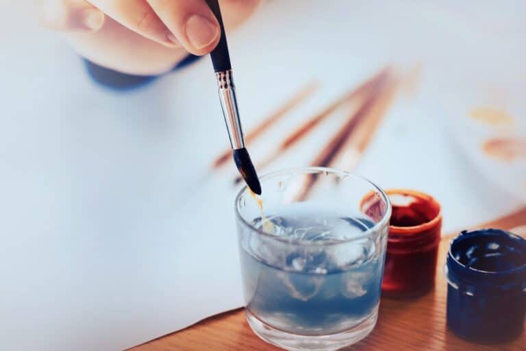 The Artist Washes The Brush In A Glass Of Water