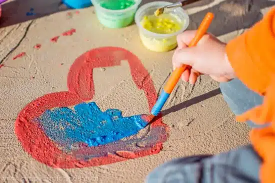 a kid painting using chalk paints