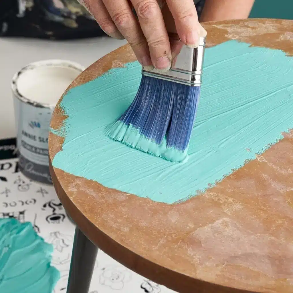 applying blue chalk paint on a table with a paint brush