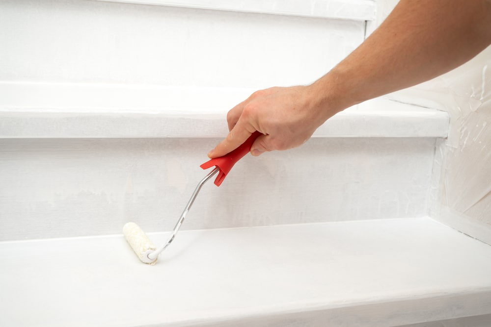 Male Hand Paints A Wooden Staircase White With Paint And