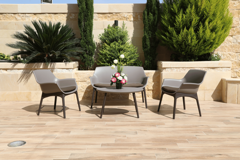 Seat chairs and plastic tables inside a garden