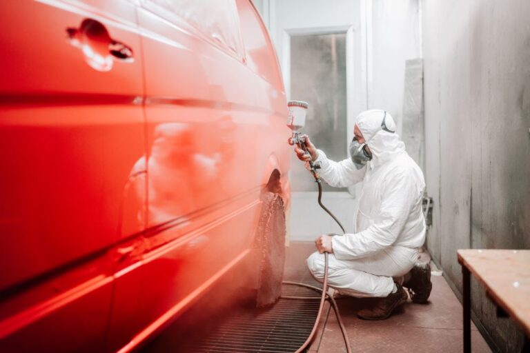 an Auto mechanic painting a car