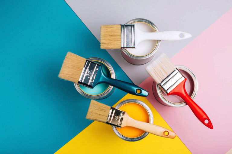 four open cans with brushes on them on bright background