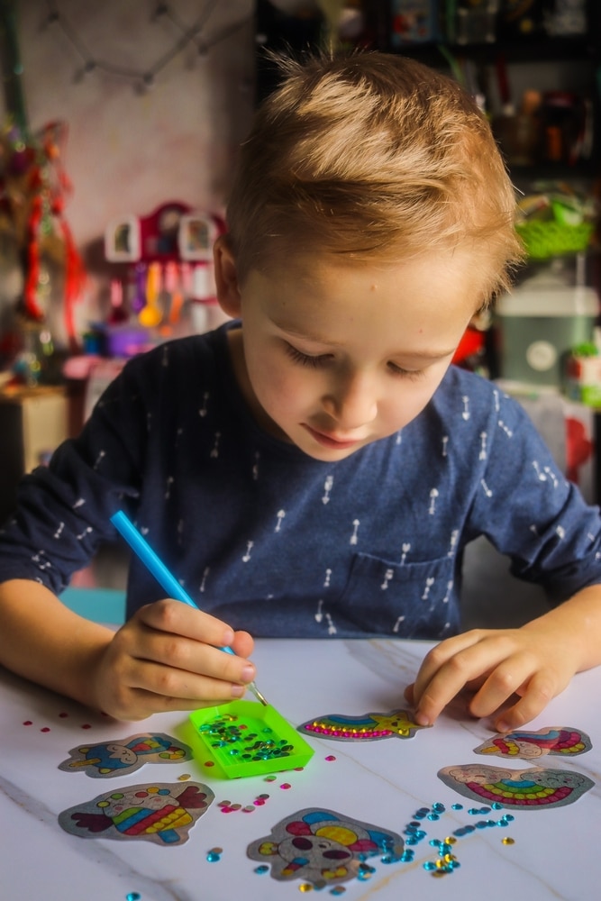 Boy Gluing Crystals In A Diamond Mosaic Set At The