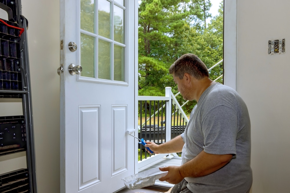 A view of a guy painting the front house door