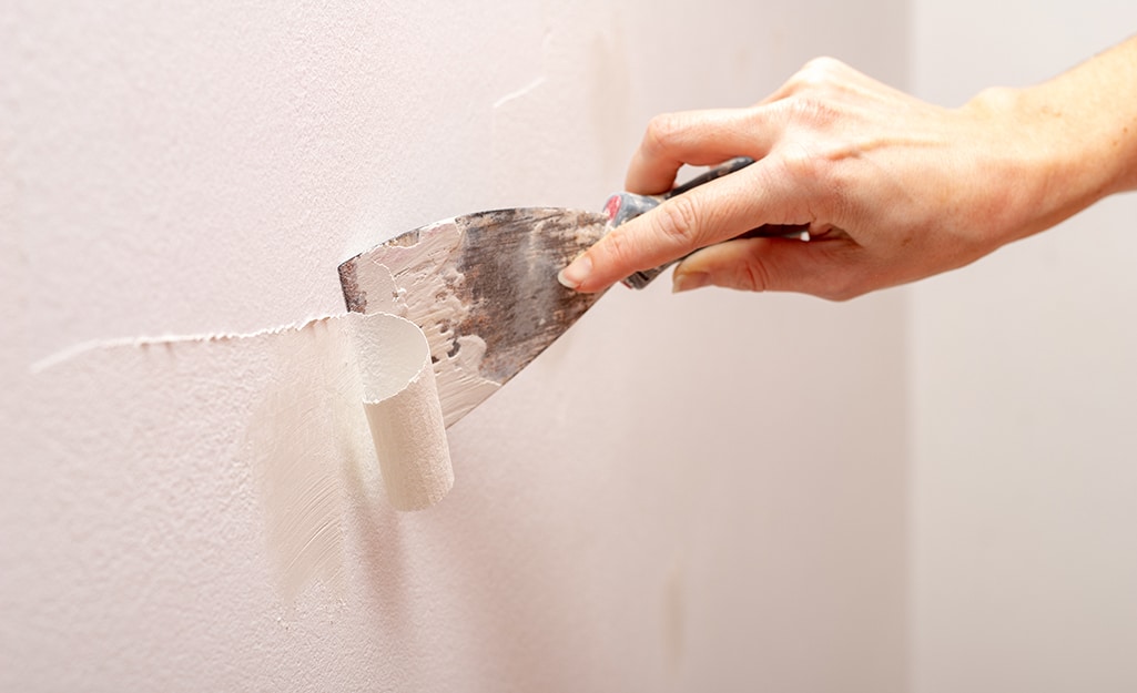 zoomed in view of a hand fixing paint peel zoomed in view of a hand fixing paint peel