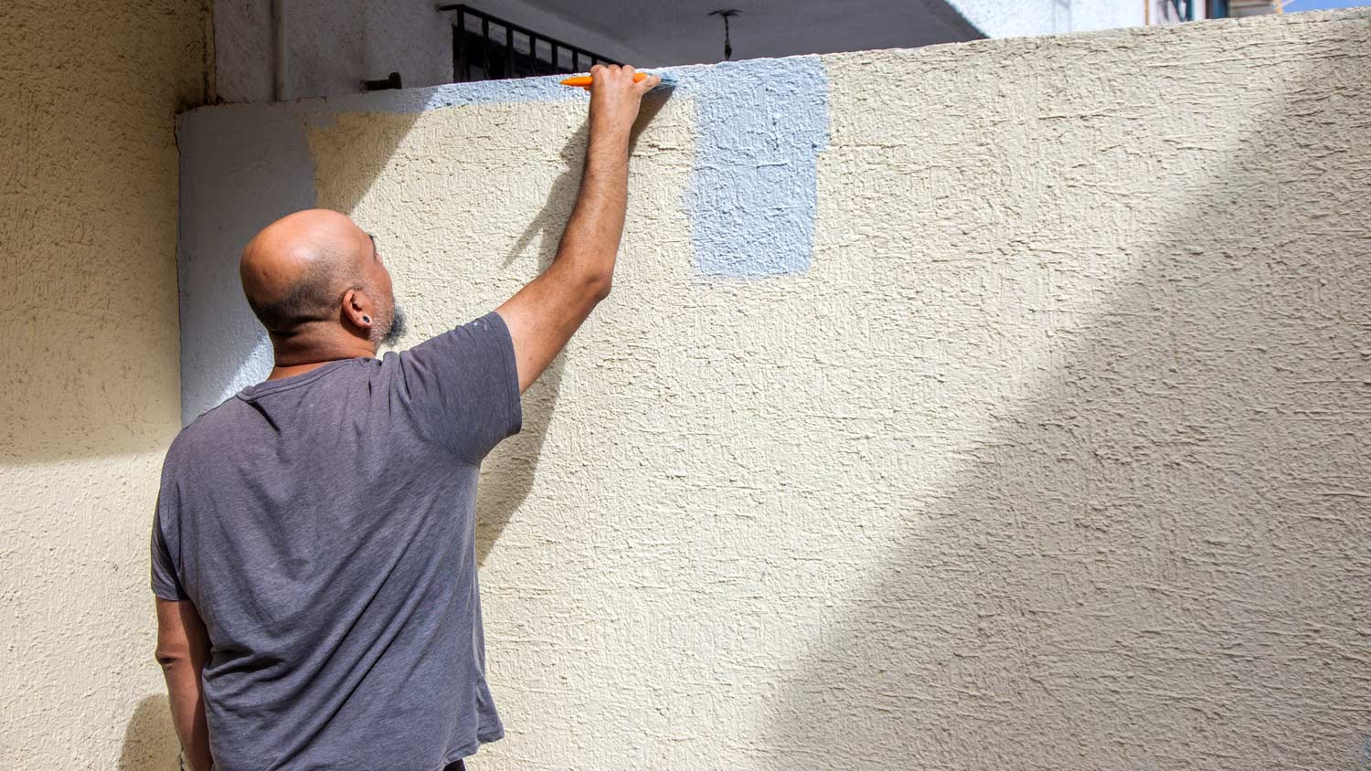 an old man applying orange peel texture on wall an old man applying orange peel texture on wall