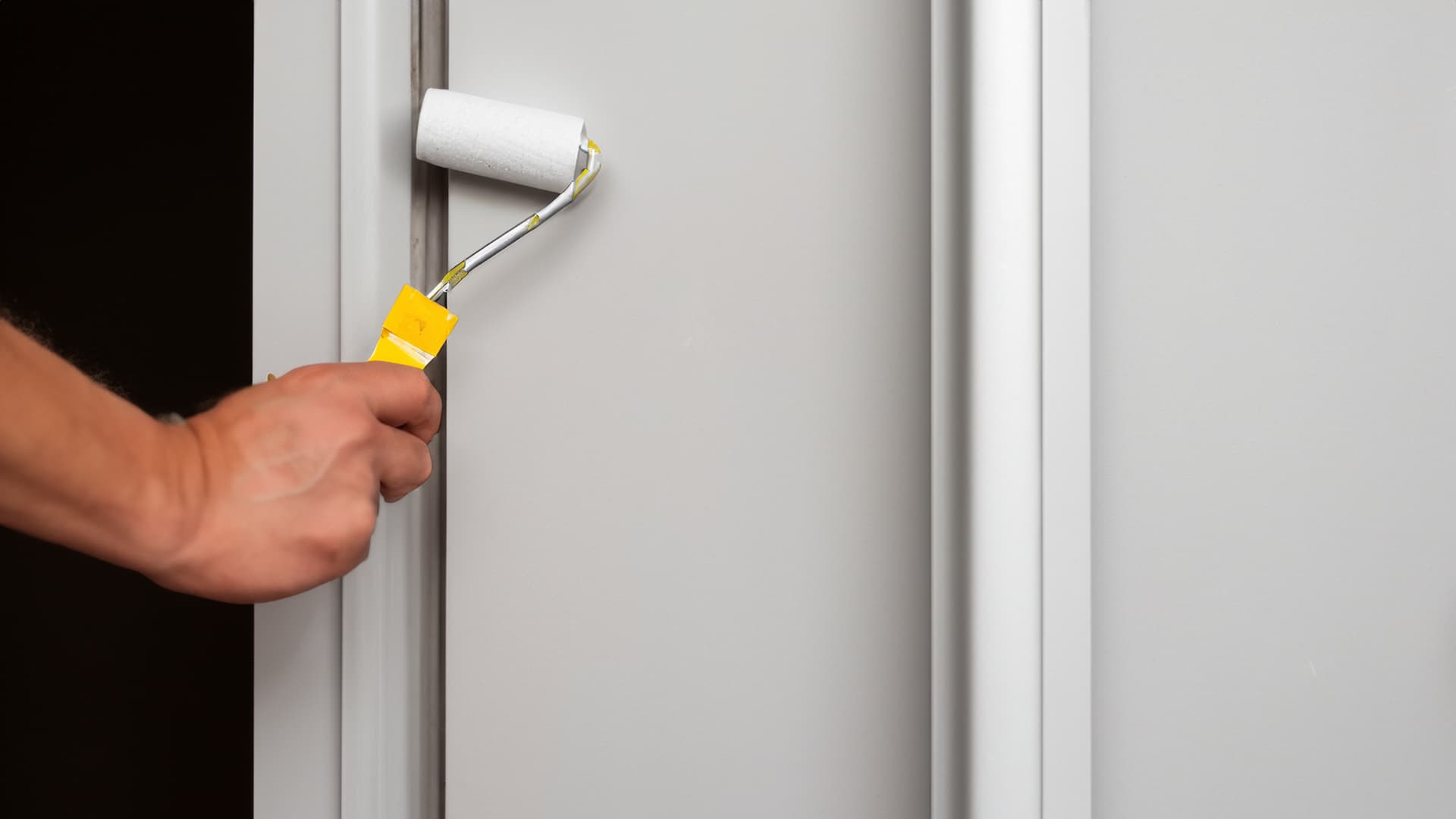 zoomed view of a hand painting a door