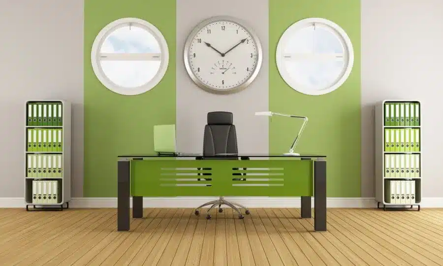 Modern office with green accents a black desk filing cabinets and a large clock Modern office with green accents a black desk filing cabinets and a large clock