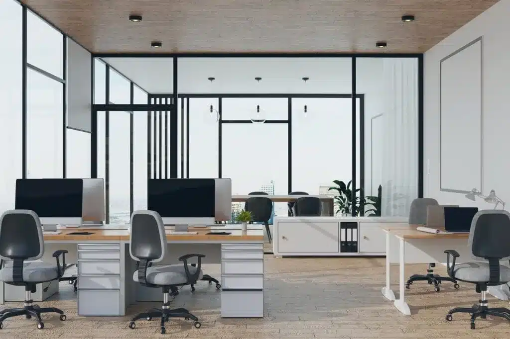 Modern office with large windows desks with computers and ergonomic chairs Modern office with large windows desks with computers and ergonomic chairs