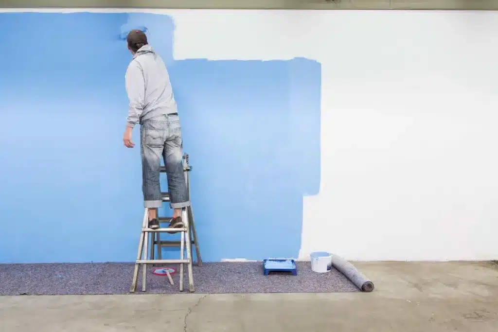 a professional painter painting a wall in blue