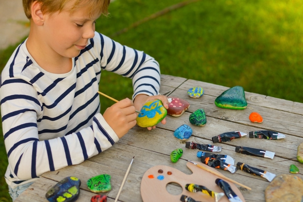 A view of a kid painting rocks A view of a kid painting rocks