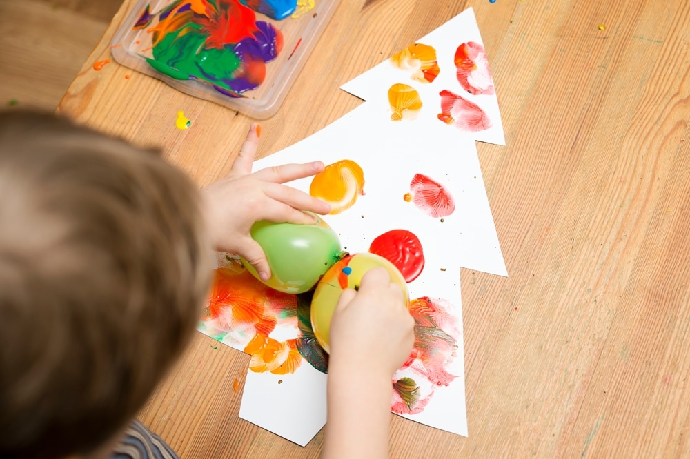 A view of a little boy painting a christmas tree A view of a little boy painting a christmas tree