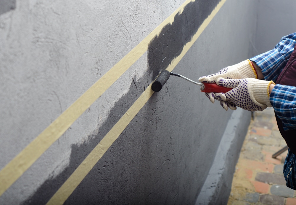 A view of a person painting the garage wall A view of a person painting the garage wall