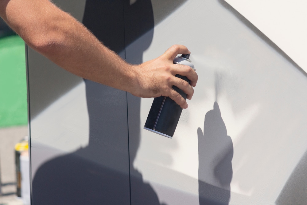 A view of a person spray painting the walls A view of a person spray painting the walls