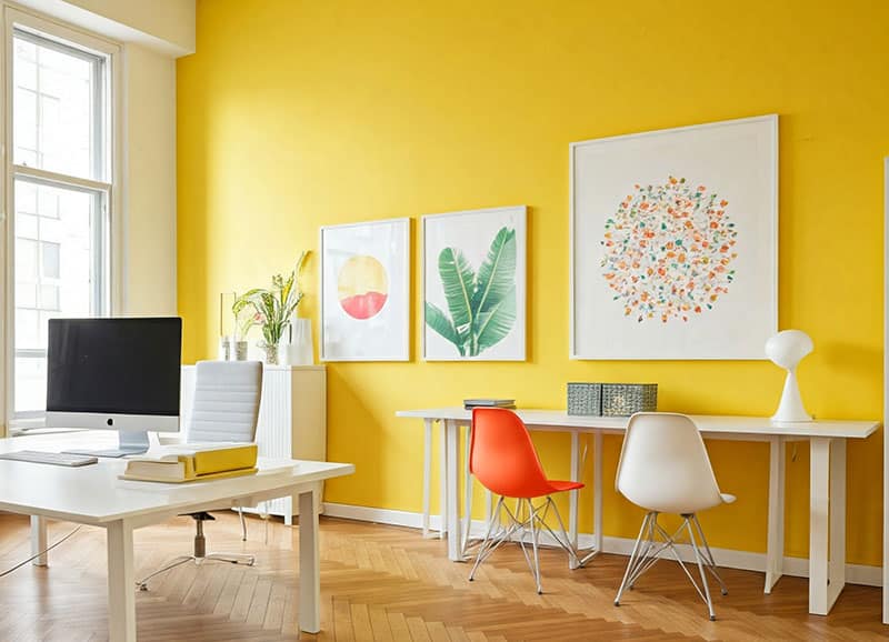 Bright yellow home office with modern furniture artwork and large windows Bright yellow home office with modern furniture artwork and large windows