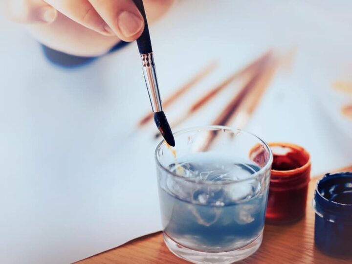 The Artist Washes The Brush In A Glass Of Water