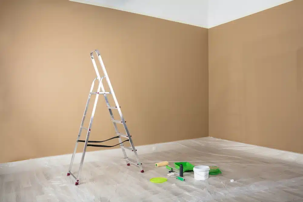 a small ladder paint related items on the floor
