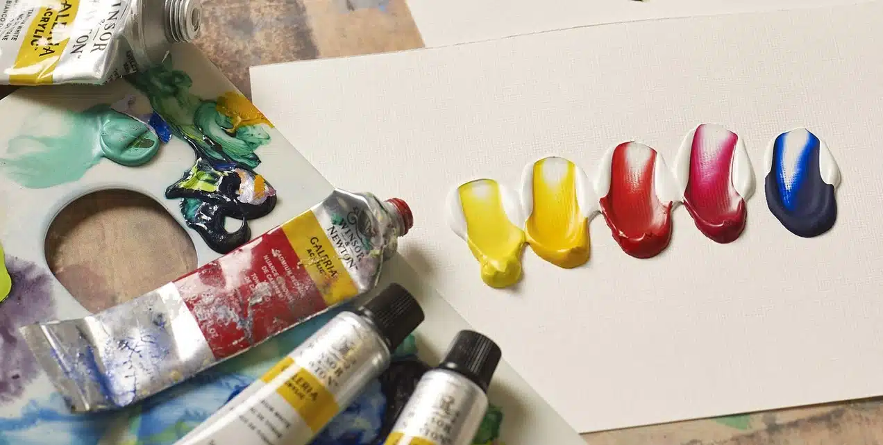 acrylic paint tubes and color swatches on board