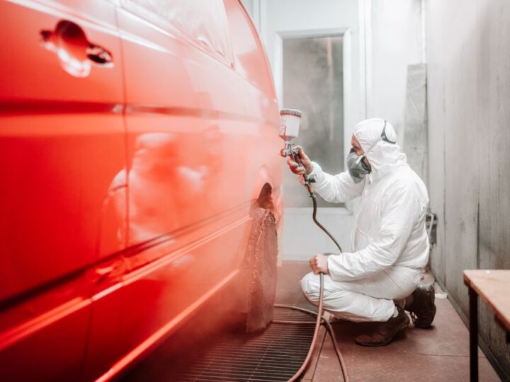 an Auto mechanic painting a car