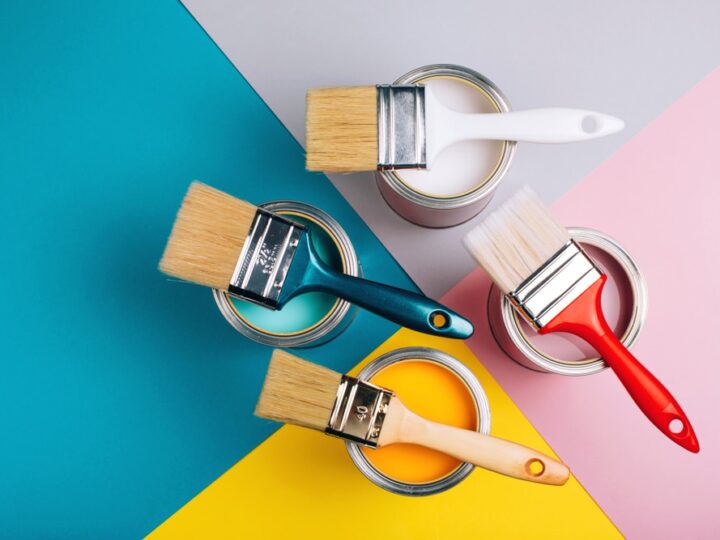 four open cans with brushes on them on bright background