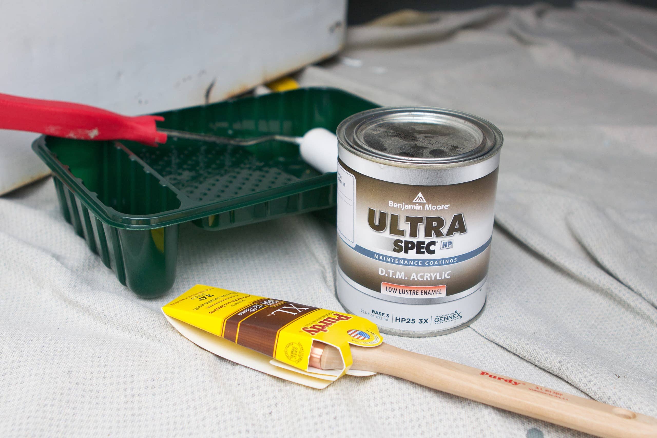 paint jar brush and a tray placed on a surface
