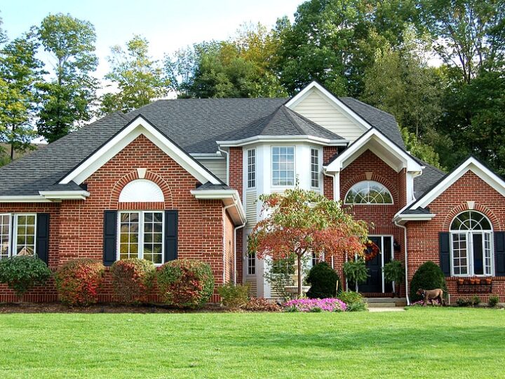 view of a red brick house with gray roof