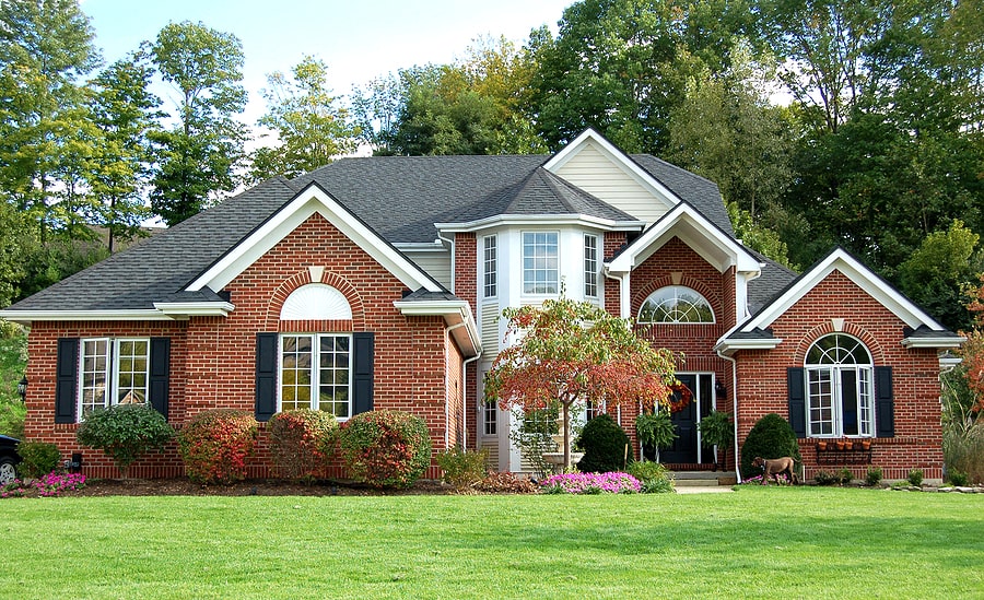 view of a red brick house with gray roof